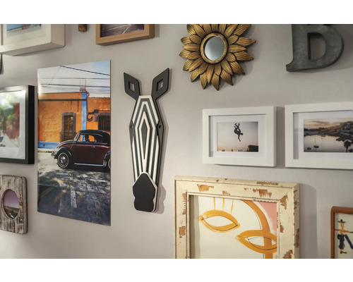 Wanddecoratie met fotolijsten, spiegel en zebrahoofd