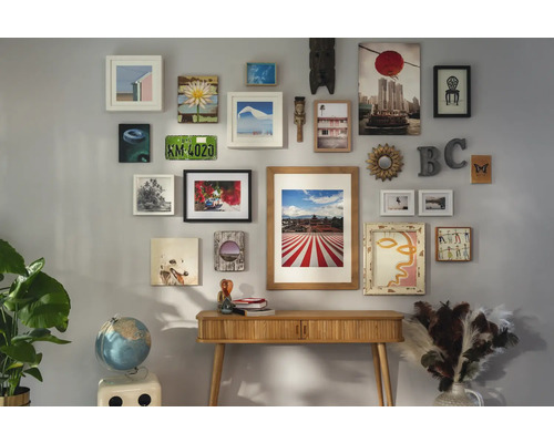 Wand met diverse foto''s en decoraties boven een houten tafel