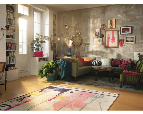 Woonkamer met hoekbank, vloerkleed, decoratie en verjaardagsslinger.