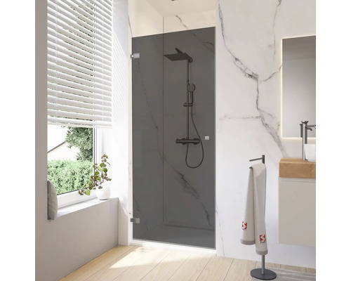 Donkere glazen douchedeur in een badkamer met marmeren wanden en houten vloer.