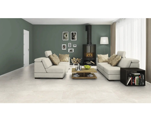 Woonkamer met zithoek, kachel, salontafel en keramische vloertegels.