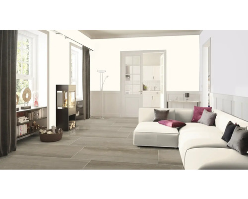 Lichte woonkamer met bank, houtkachel, boekenkast en raam