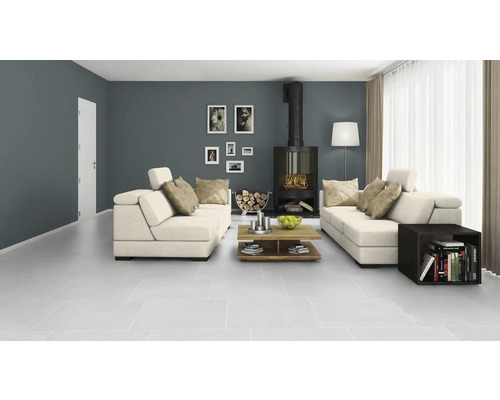 Lichte woonkamer met open haard, banken en tegelvloer