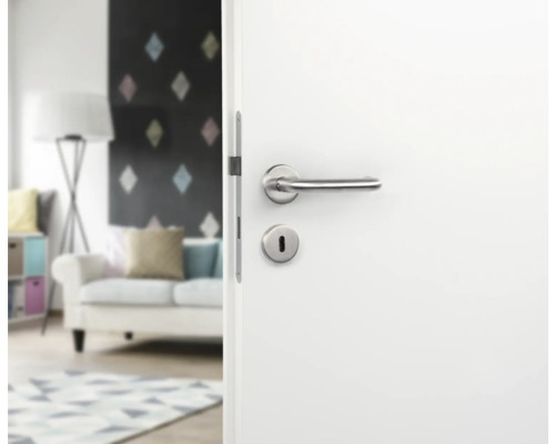 Witte deur met zilverkleurige deurklink en sleutelgat in woonkamer