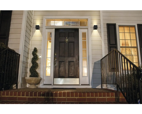 Entree van een huis met verlichte buitenwandlampen