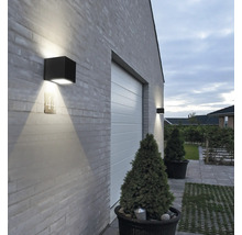 Buitenkant van een huis met garagedeur en vierkante wandlampen