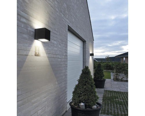 Buitenkant van een huis met garagedeur en vierkante wandlampen