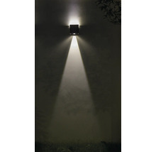 Vierkante wandlamp schijnt licht naar beneden op een muur