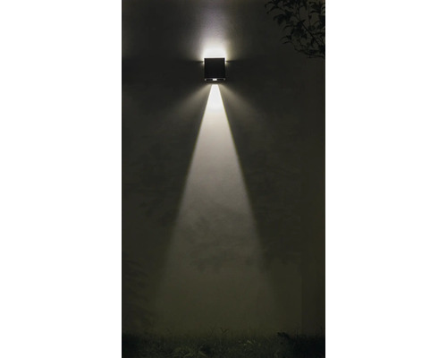 Vierkante wandlamp schijnt licht naar beneden op een muur