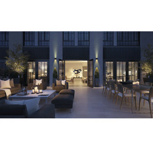 Groot terras met zithoek, eettafel en decoratie in de avond.