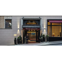 Buitenaanzicht van de ingang van het Executive Hotel Pacific met bewaker