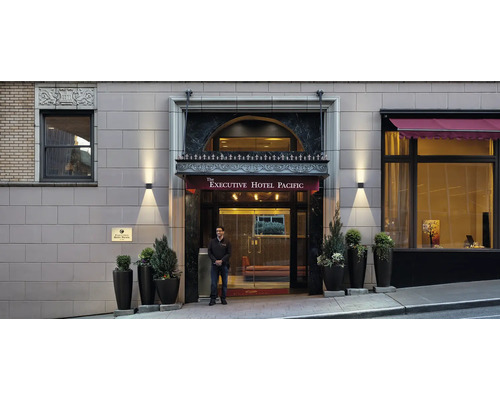 Buitenaanzicht van de ingang van het Executive Hotel Pacific met bewaker