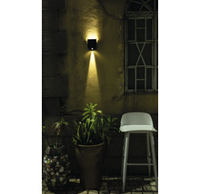 Scene met buitenmuurlamp, bloempotten en stoel in de tuin