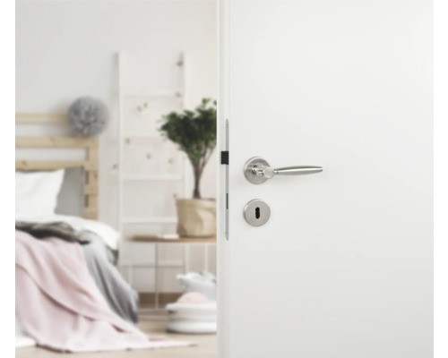 Open witte deur met zilverkleurige deurklink in slaapkamer