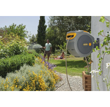 Wandslangbox in tuin met familie die planten water geeft