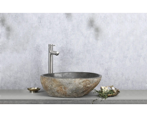 De afbeelding toont een wastafel van steen en een waterkraan.