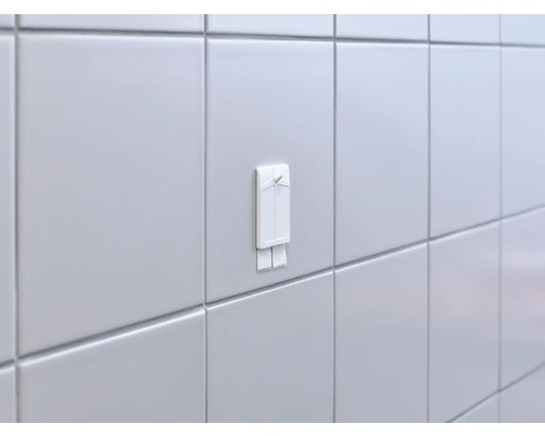 Tegelwand met bevestigde zelfklevende haak