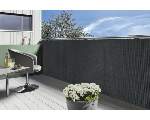 Balkon met privacyscherm, stoel, tafel en bloempot met madeliefjes