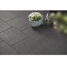 Donkere vloertegels gelegd met plant en decoratie