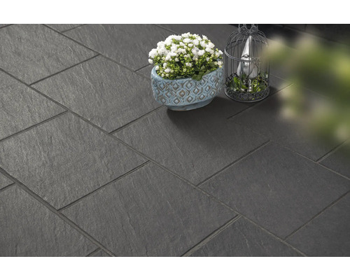 Donkere vloertegels gelegd met plant en decoratie