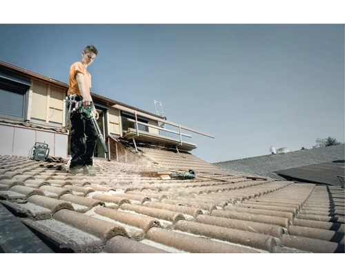 Man reinigt dak met bladblazer en accupack