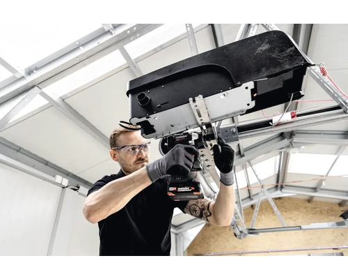 Vakman monteert een garagedeuropener met een accuschroevendraaier van Metabo