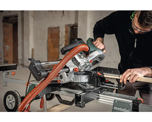 Een persoon bedient een Metabo afkort- en verstekzaag op een werktafel.