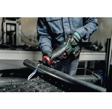 Een persoon snijdt een metalen buis door met een Metabo reciprozaag.