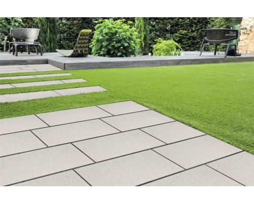 Tuin met gazon en pad van stenen platen