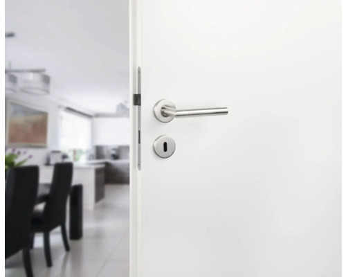 Openstaande witte binnendeur met zilverkleurige deurklink