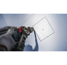 Oscillerend multifunctioneel gereedschap dat een vierkante opening in een wand snijdt.