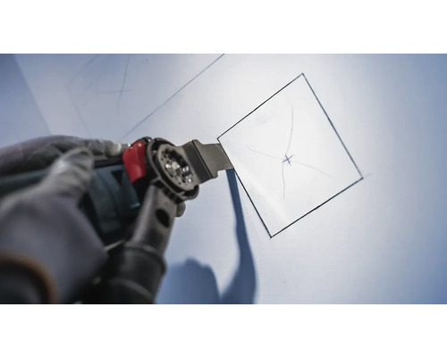 Oscillerend multifunctioneel gereedschap dat een vierkante opening in een wand snijdt.
