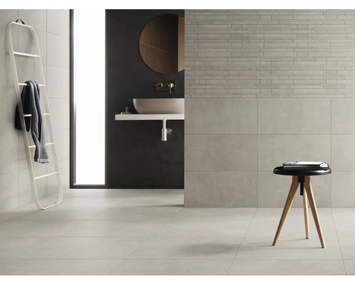 Lichte badkamer met tegels, wastafel en ladderrek voor handdoeken