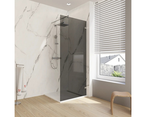 Glazen douchewand met kraan in een lichte badkamer.