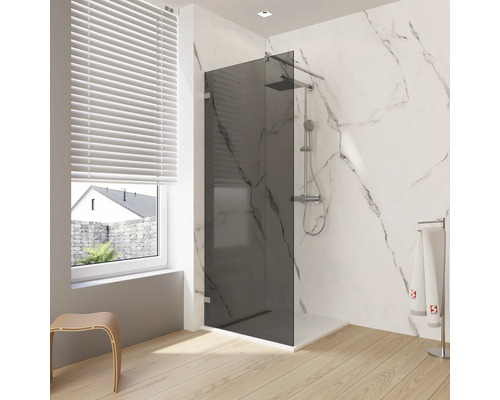 Badkamer met glazen douchecabine, douchekop, handdoekrek en houten vloer.