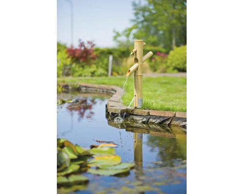 Bamboe fontein met drie wateruitlopen aan de rand van de vijver