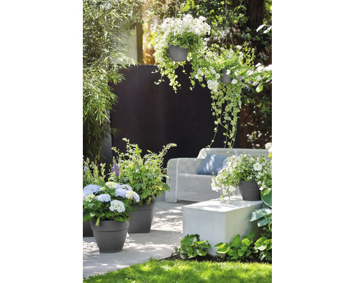 Tuin met plantenbakken, hangpotten en zitplaatsen voor een ontspannen sfeer