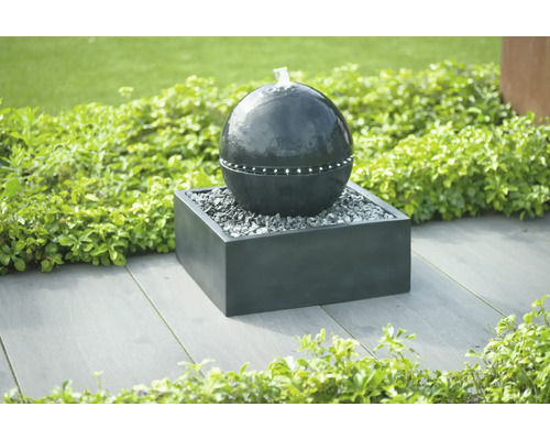 Decoratieve tuinfontein bol op een voetstuk met grind