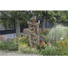Tuin met decoratieve boomstamfontein en bloemen