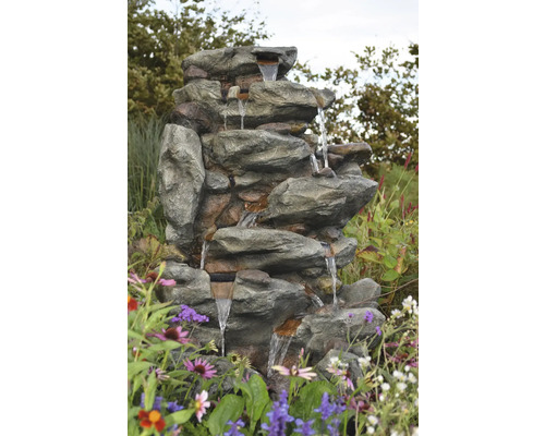 Tuinfontein met steenlook en watercascades in een bloembed