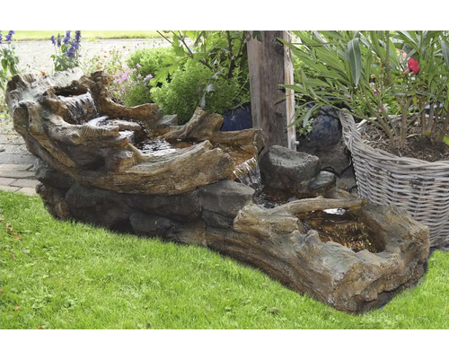 Tuinfontein van kunststeen in boomstamlook met waterspel