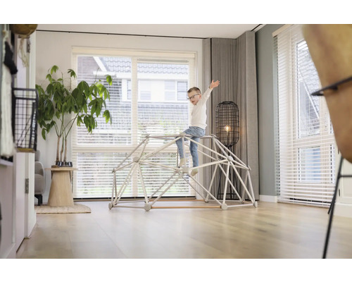 Kind speelt op een klimrek in de woonkamer.