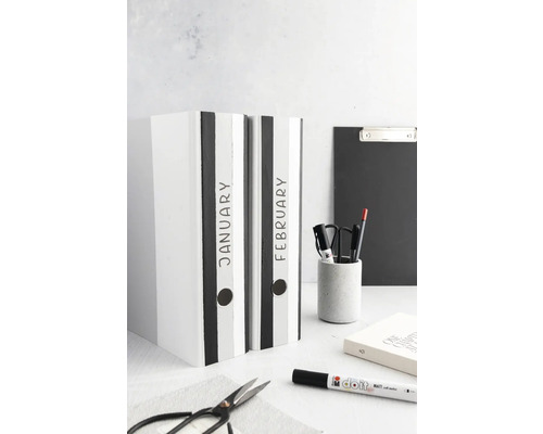 Twee ordners met de opschriften januari en februari staan op een tafel.