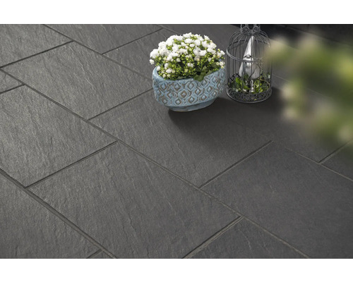 Donkere terrastegels gelegd met decoratie.