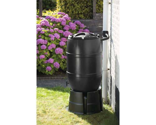 Regenton met deksel en aftapkraan op een voetstuk in de tuin