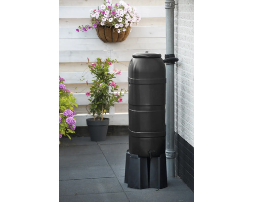 Regenton van kunststof op een voetstuk met planten op de achtergrond