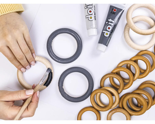 "Iemand schildert een houten ring met een penseel