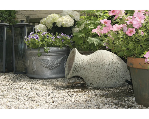 Tuinscene met terracotta amfoor, beplante bloempotten en grindvloer