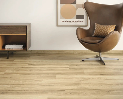 Lichte woonkamer met laminaatvloer, fauteuil en commode