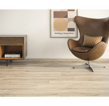 Scene met laminaatvloer, fauteuil en bijzettafel voor een moderne woonkamer.
